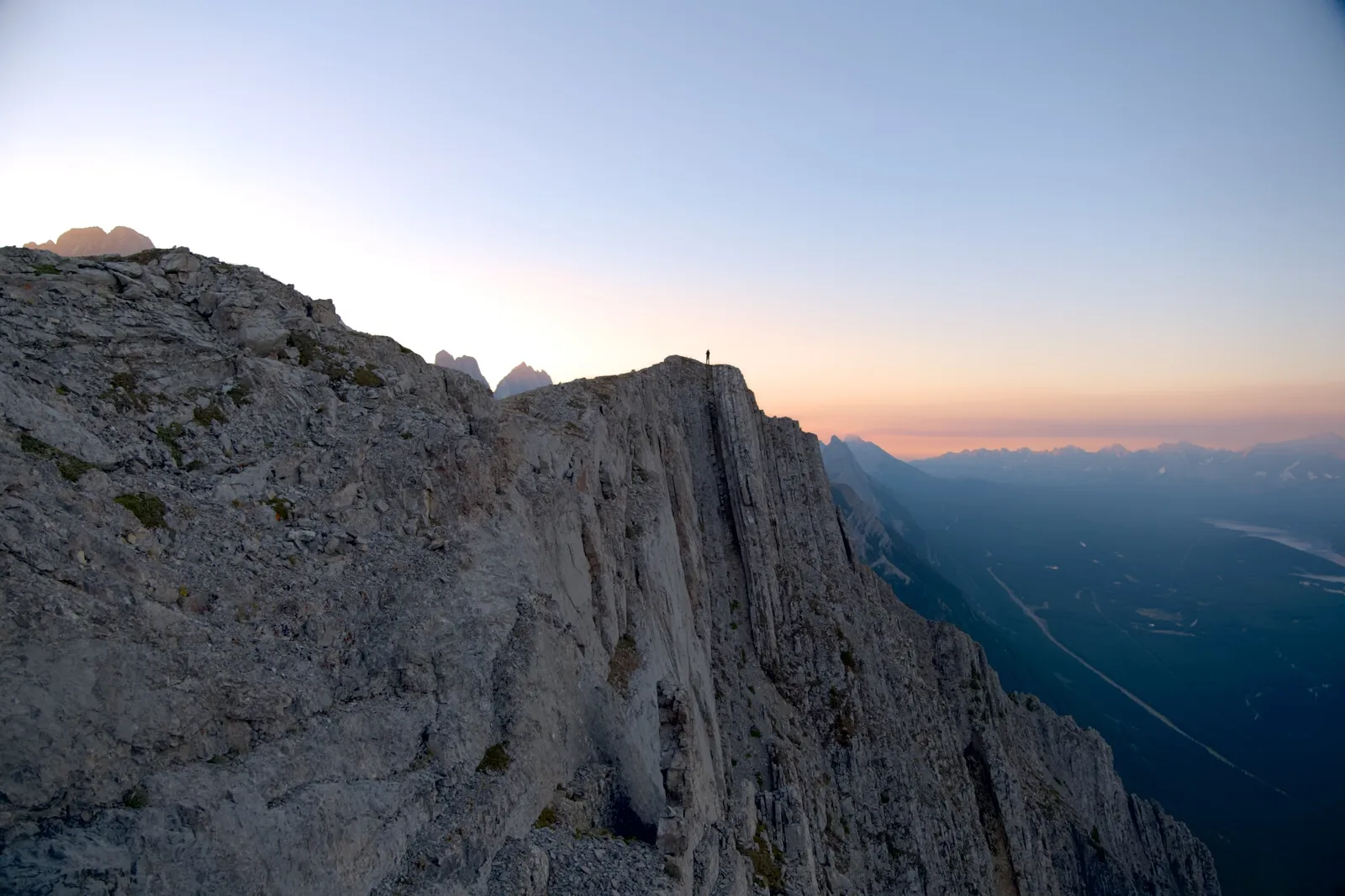 The same photo developed: the rock face opens up, the sky turns blue with a pink band on the horizon